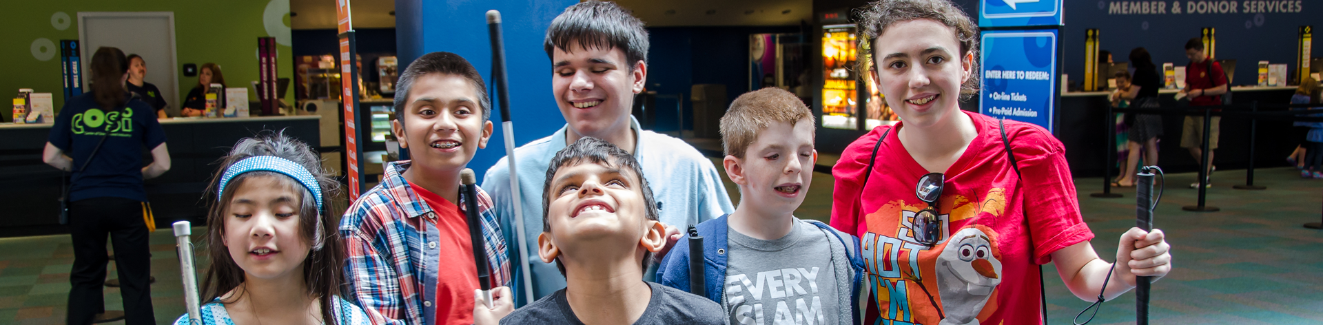 A group of blind students and mentors smile together for a photo during an NFB STEM2U program.